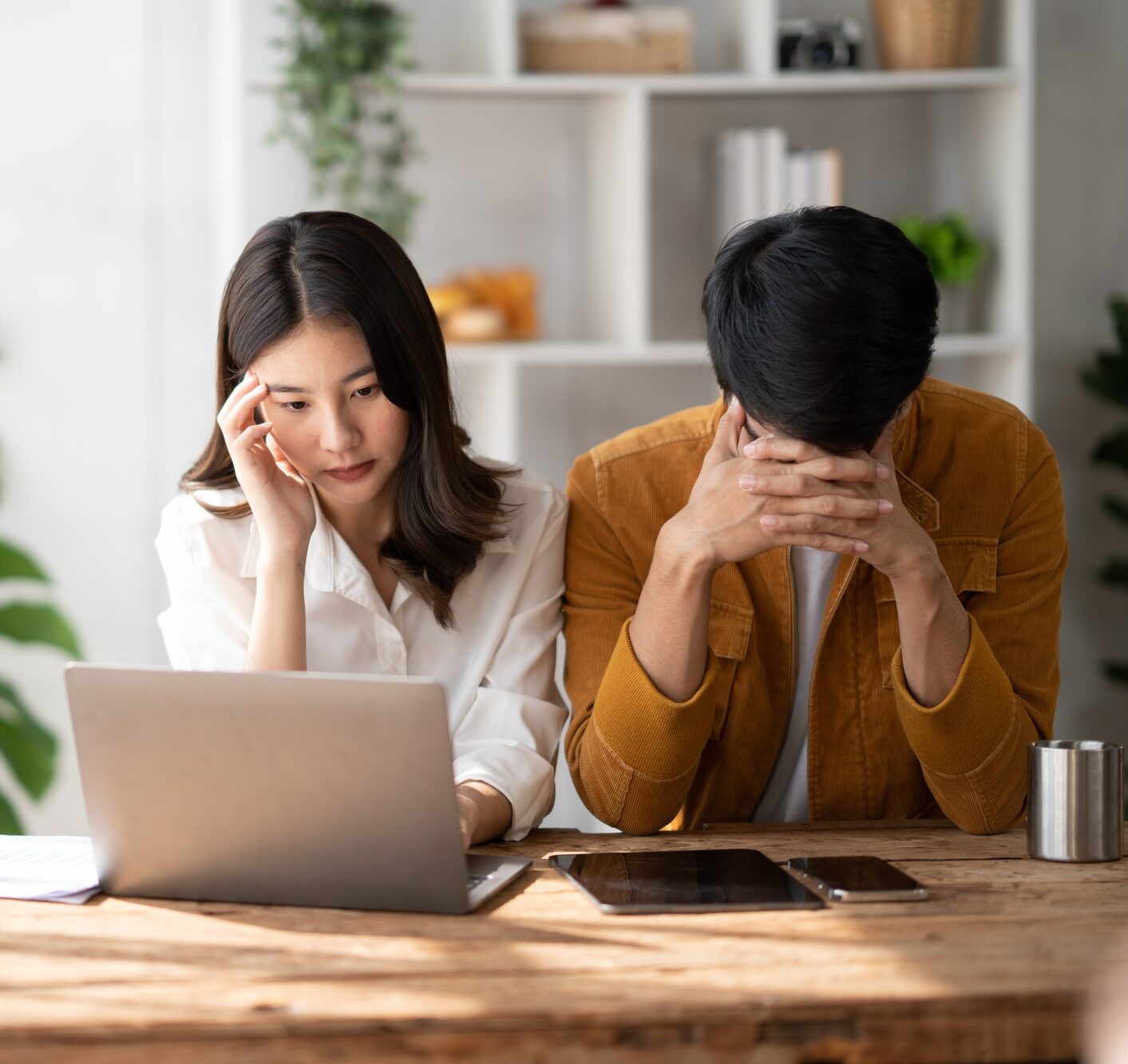 Stress, anxiety and worry with a young couple struggling with finance, debt and the home budget in t
